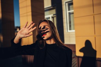 Portrait of woman standing against wall