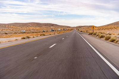 Road passing through landscape against sky