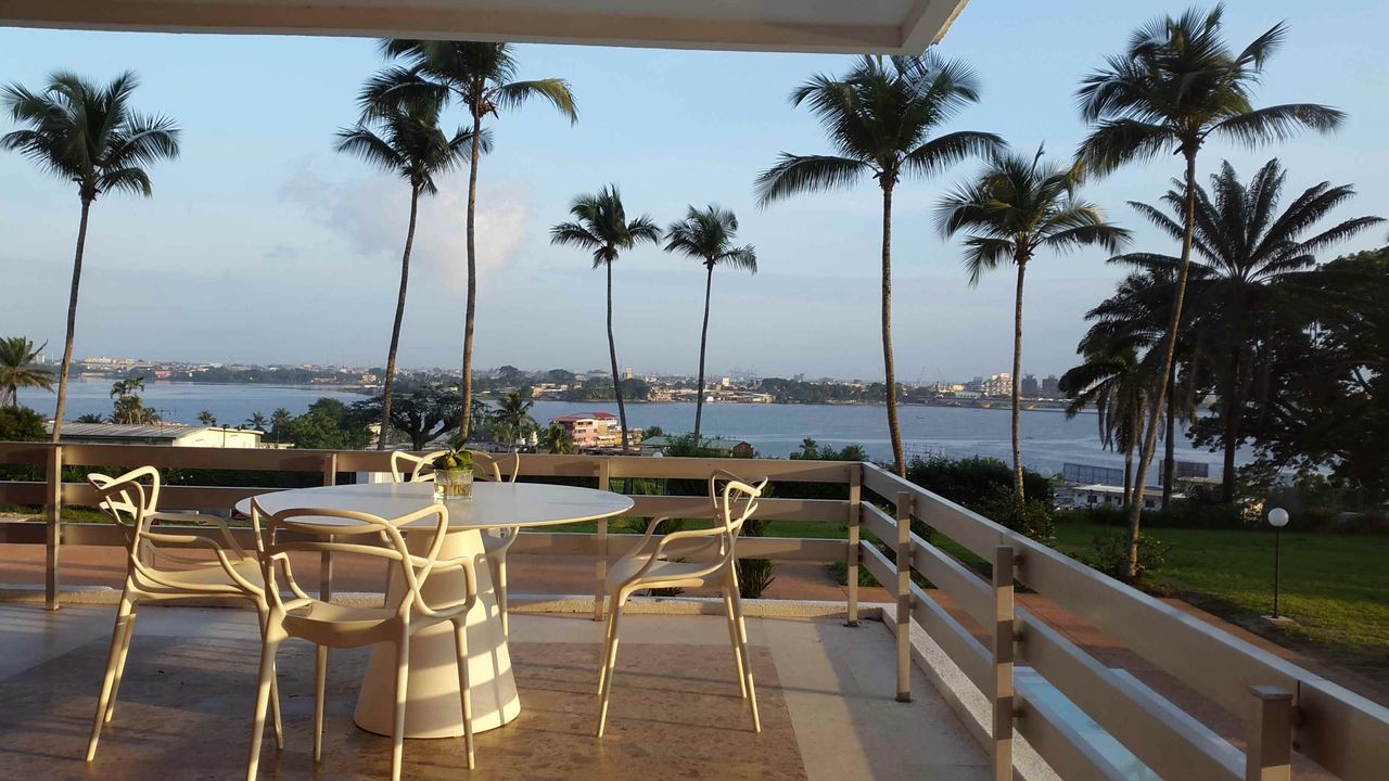 chair, sea, water, palm tree, tree, table, lounge chair, empty, absence, sky, relaxation, swimming pool, beach, horizon over water, tourist resort, tranquil scene, tranquility, sunlight, vacations, bench