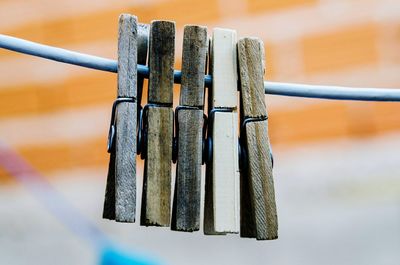 Close-up of wooden pegs hanging on clothesline