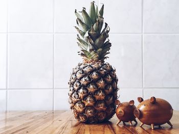 Close-up of pineapple and piggybanks on table