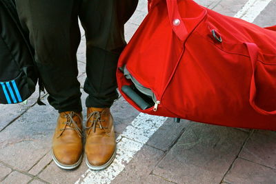 Low section of person with luggage on footpath