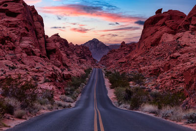 Road amidst rocks against sky