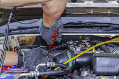 Midsection of mechanic repairing car