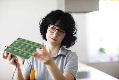 Young woman working as electronics technician