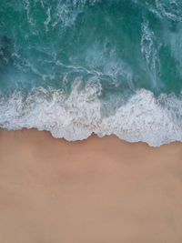 High angle view of waves rushing at beach