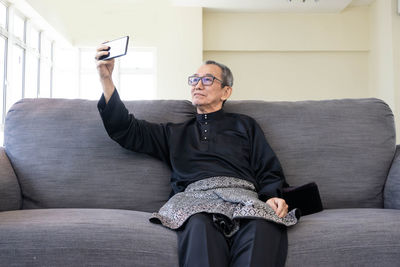 Young man sitting on sofa