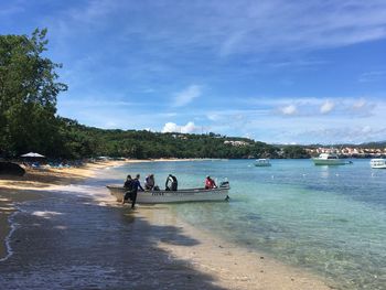 People at beach against sky