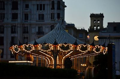Illuminated city against sky at night
