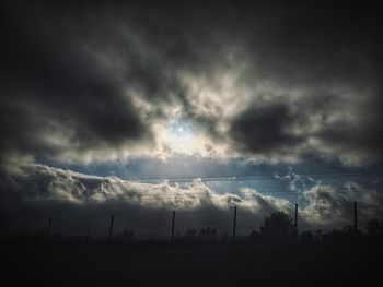 Silhouette of field against cloudy sky