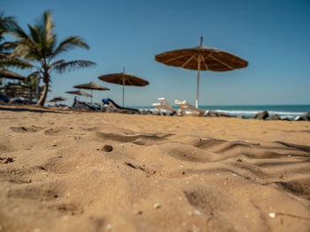 Beach umbrellas by sea against sky