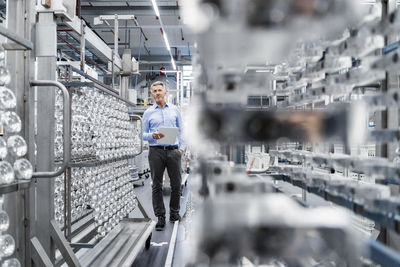 Businessman checking production line at automated industry