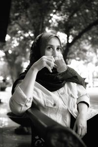 Portrait of young woman sitting outdoors