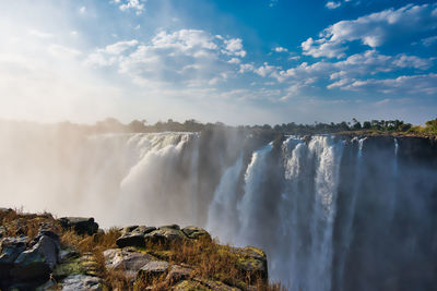 Panoramic view of waterfall against sky