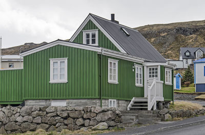 Traditional house with ground floor, basement and attic, with green wooden facades