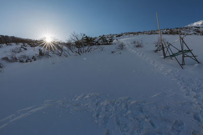 Scenic view of snow covered land against sky