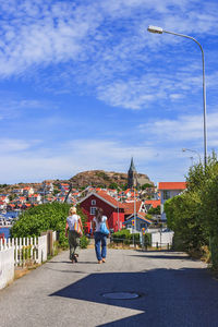 Two young women walking on a street in a coastal village