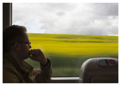 Portrait of man in train against sky