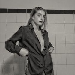 Portrait of beautiful young woman standing against wall