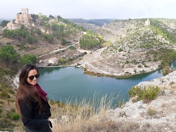 Young woman wearing sunglasses standing on mountain