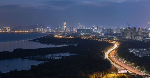 High angle view of illuminated buildings against sky at night