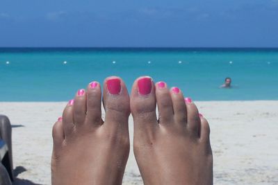 Low section of woman relaxing on beach