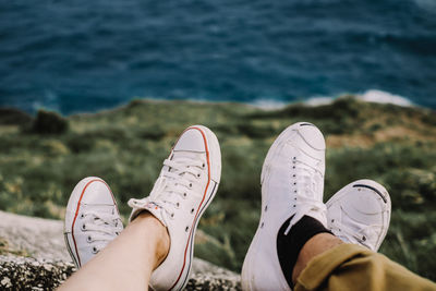 Low section of people wearing canvas shoes at beach