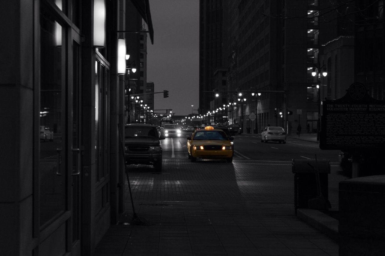 transportation, building exterior, architecture, car, built structure, city, land vehicle, mode of transport, illuminated, street, night, road, city street, city life, street light, the way forward, building, traffic, outdoors, diminishing perspective