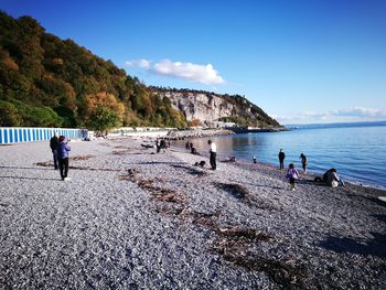 People at beach against sky