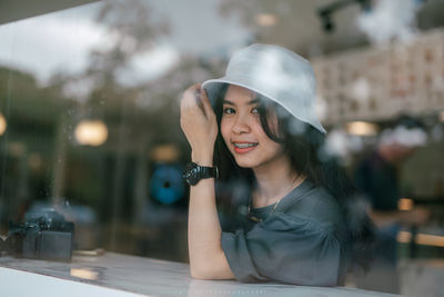 Portrait of smiling young woman wearing hat