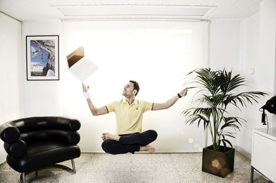 Full length of man levitating in living room 
