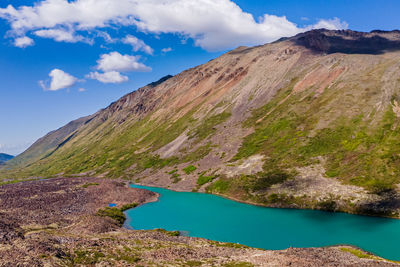 Scenic view of lake by mountains against sky