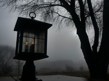 Close-up of illuminated lamp hanging against sky