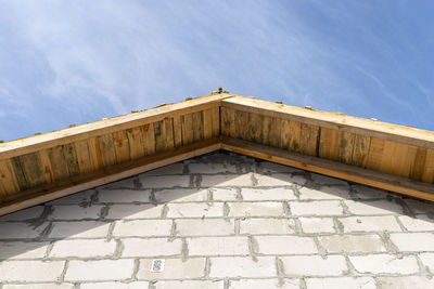 The top of the roof is completely covered with boards, raw walls and roof truss are visible.