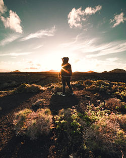 Man standing on mountain against sky during sunset