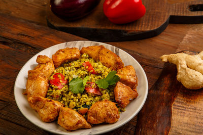 Food for suhoor in ramadan bulgur post with beef in a plate on a wooden table next to vegetables 