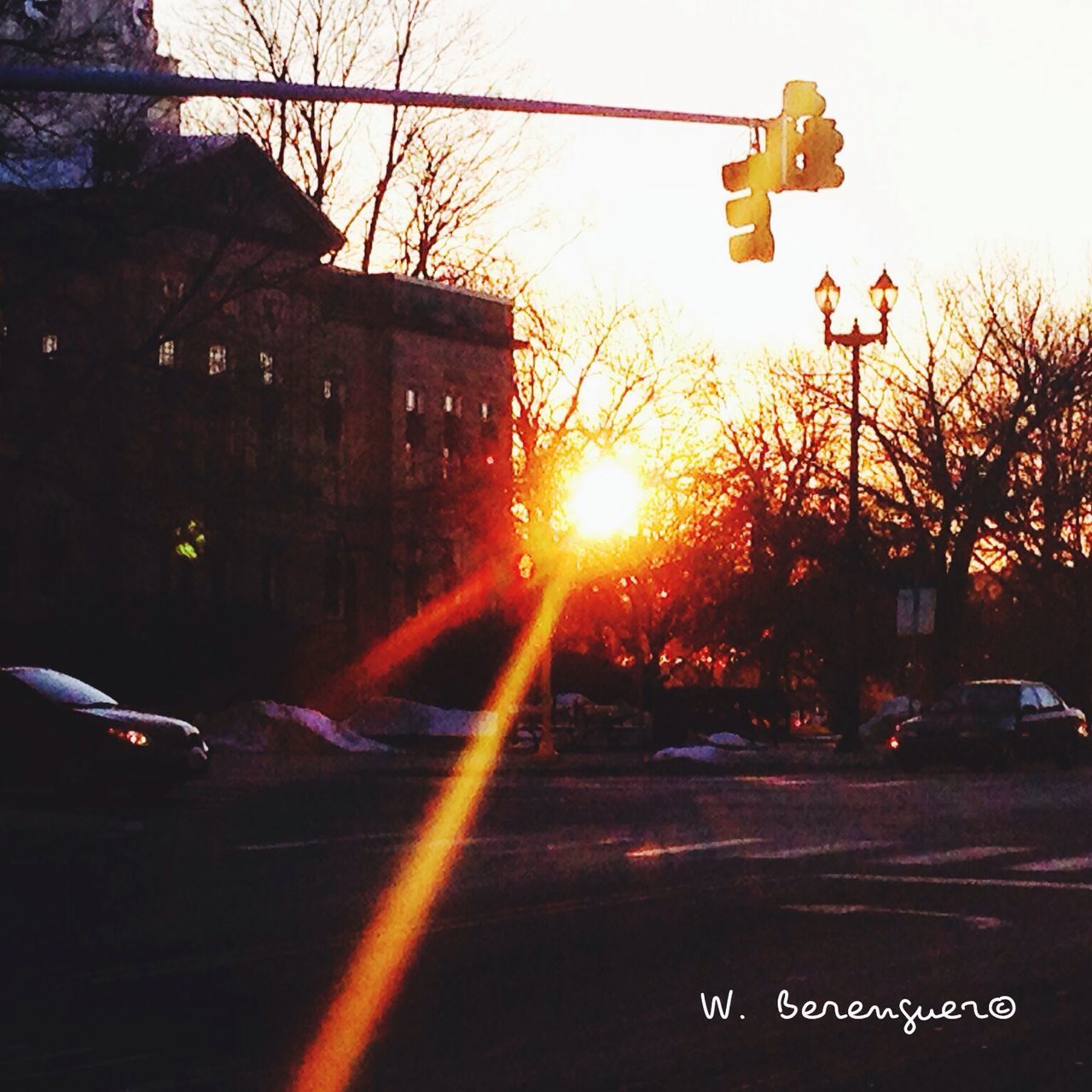 sunset, car, transportation, building exterior, land vehicle, built structure, architecture, mode of transport, sun, street, tree, city, road, sunlight, silhouette, bare tree, clear sky, orange color, city street, traffic