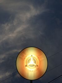 Low angle view of illuminated street light against sky