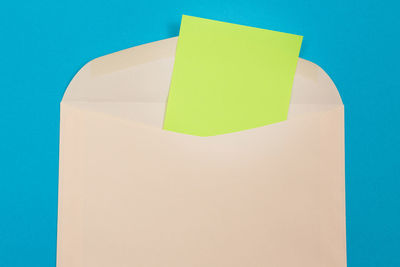 Close-up of yellow paper against blue background