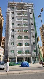 People on street against buildings in city