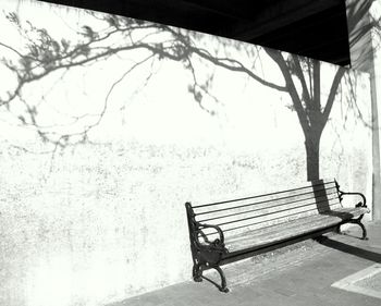 Empty bench against wall