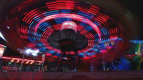 Low angle view of illuminated ferris wheel at night