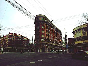 Electricity pylon with buildings in background