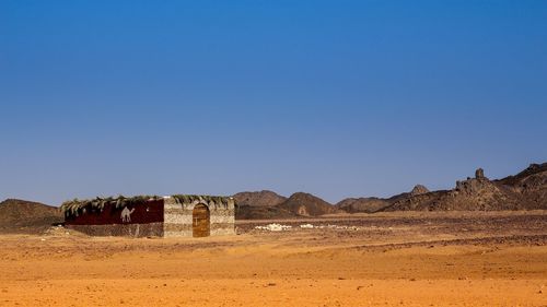 Scenic view of desert against clear blue sky