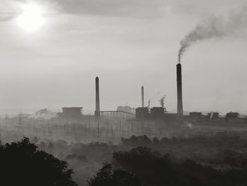 Smoke emitting from chimney against sky