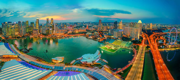 High angle view of illuminated buildings against cloudy sky