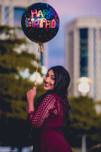 Portrait of a smiling young woman with balloons