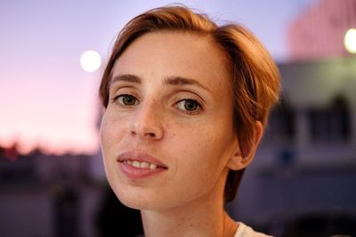 Close-up portrait of young woman against sky