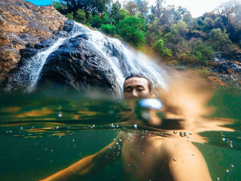 Portrait of man against waterfall