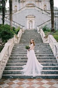 Rear view of woman with umbrella on staircase